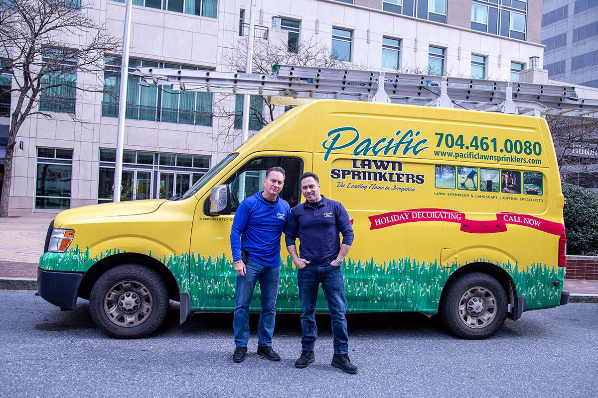 Two person posing infront of truck