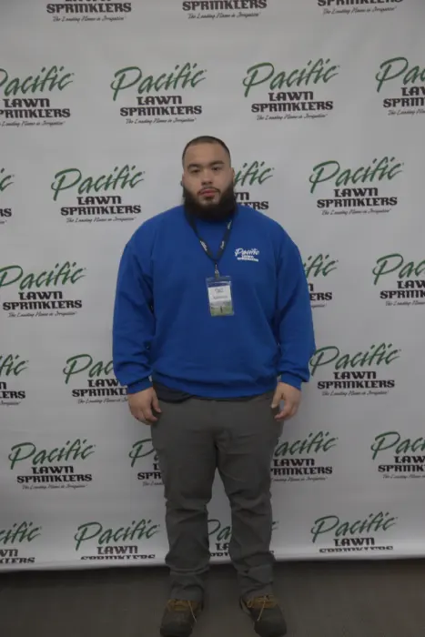 A person in a blue sweatshirt stands in front of a backdrop with "Pacific Lawn Sprinklers" logo.